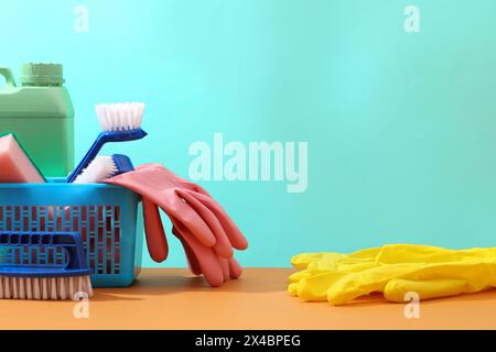 Szene für Werbung für Reinigungsprodukte, Reinigungsservice mit Kopierraum. Ein blauer Korb gefüllt mit Waschmittelflasche, Bürsten, Gummihandschuhen und spo Stockfoto