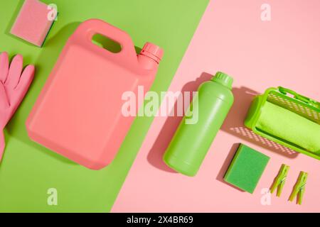 Minimale Szene für Werbung für Reinigungsprodukte mit leerem Platz für Design. Eine grüne Flasche und rosafarbene Kunststoffkanisterbehälter-Reinigungsmittel werden angezeigt Stockfoto