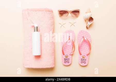 Sommerferienkonzept. Blick von oben auf Strandtuch, Flip Flop und Sonnencreme Draufsicht mit Kopierraum für Text. Stockfoto