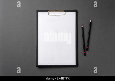 Leeres A4-Papier, das an der Zwischenablage befestigt ist, und Bleistift darauf Stockfoto