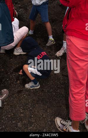 Besucher auf dem Ätna in Sizilien (Italien) über 2.500 m tragen Turnschuhe oder Turnschuhe (d. h. „geschlossene“ Schuhe mit dicken Sohlen), um auf der kalten Lava (Ischiare) zu laufen, die noch Wärme aus einem noch nicht erstarrten Kern abgeben kann. Stockfoto