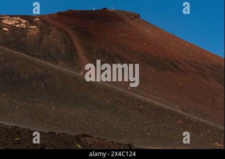 Touristen schlendern die lange, von Menschenhand geschaffene Rampe auf dem Ätna in Sizilien, Italien. Die Rampe führt zum Rand eines erloschenen Kraters, der den Gipfel umgibt. Stockfoto