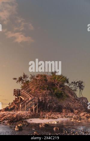 Kleine Insel mitten am Strand von Byron Bay in Australien, die wie die Geschichte aus dem Buch der kleine Prinz im rosa Licht der Sonne aussieht Stockfoto