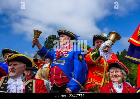 Stadtschreier (Pagen und Pagen in bunten Flechtbrillen und Uniformen), die in Gruppe, Lächeln und Posen stehen - Ilkley, West Yorkshire, England, Großbritannien. Stockfoto