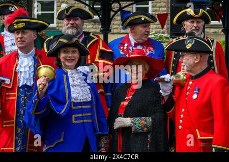 Stadtschreier (Pagen und Pagen in bunten Flechtbrillen und Uniformen), die in Gruppe, Lächeln und Posen stehen - Ilkley, West Yorkshire, England, Großbritannien. Stockfoto