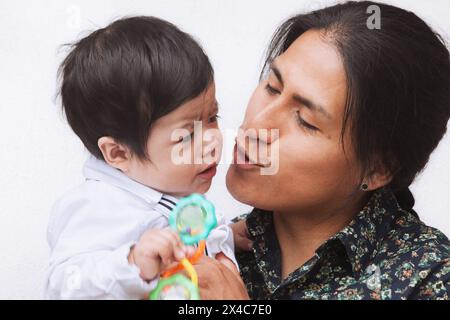 Ein ecuadorianischer Vater zeigt Zuneigung zu seinem Baby und hebt familiäre Bindungen und kulturelle Traditionen in einem zärtlichen Moment hervor. Stockfoto