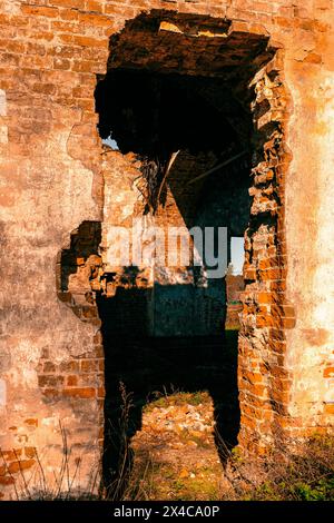 Bogenförmiger Eingang zu einem Backsteinruine. Ausgewählter Fokus. Vertikales Foto. Hochwertige Fotos Stockfoto