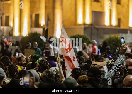 Tiflis, Georgien. Mai 2024. Während einer Demonstration vor dem georgischen Parlament wird eine georgische Flagge unter einer Menge von Demonstranten hoch gehalten. Tausende haben an einem Protest gegen die zweite Lesung eines Gesetzes teilgenommen, das zur Vornahme eines umstrittenen Gesetzes über "ausländische Agenten" gestimmt wurde, das wochenlange Massenproteste in der Hauptstadt Tiflis ausgelöst hat. Quelle: SOPA Images Limited/Alamy Live News Stockfoto