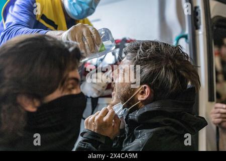 Tiflis, Georgien. Mai 2024. Einem jungen Mann wird von einem Arzt Wasser in die Augen gespritzt, nachdem ihm während einer Demonstration vor dem georgischen Parlament Pfeffer eingesprüht wurde. Tausende haben an einem Protest gegen die zweite Lesung eines Gesetzes teilgenommen, das zur Vornahme eines umstrittenen Gesetzes über "ausländische Agenten" gestimmt wurde, das wochenlange Massenproteste in der Hauptstadt Tiflis ausgelöst hat. Quelle: SOPA Images Limited/Alamy Live News Stockfoto