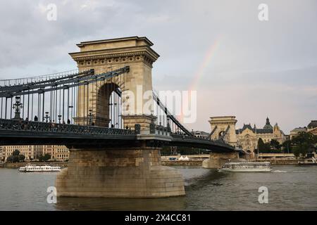 (240502) -- BUDAPEST, 2. Mai 2024 (Xinhua) -- Ein Regenbogen ist hinter der Kettenbrücke in Budapest, Ungarn, am 17. August 2023 abgebildet. (Xinhua/Zheng Huansong) Stockfoto