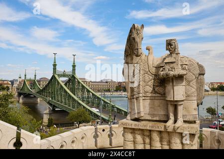 (240502) -- BUDAPEST, 2. Mai 2024 (Xinhua) -- dieses Foto vom 23. Juni 2022 zeigt eine Statue des Heiligen Stephan, des Gründungskönigs von Ungarn, und die Wahrzeichen der Freiheitsbrücke in Budapest, Ungarn. (Xinhua/Meng Dingbo) Stockfoto