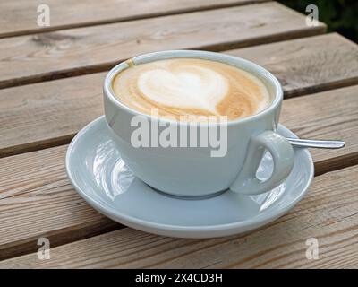 Nahaufnahme einer Tasse Latte auf einem Holztisch Stockfoto