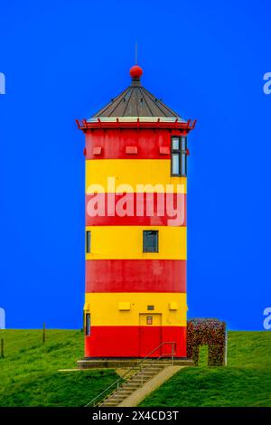 Pilsumer Leuchtturm an der Norseeküste, Krummhörn, Ostfriesland. In dem rot-gelb-geringelten Turm in der Nähe von Greetsiel ist ein Hochzeitszimmer vom Standesmt Krummhörn. Der Leuchtturm wurde durch den Film Otto der Außerfriesische des Komikers Otto Waalkes bekannt und ist eines der Wahrzeichen Ostfrieslands. Pilsum Niedersachsen Deutschland *** Pilsum-Leuchtturm an der Nordseeküste Krummhörn, Ostfriesland im rot-gelb umringten Turm bei Greetsiel befindet sich ein Hochzeitszimmer vom Krummhörner Standesamt der Leuchtturm wurde durch den Film Otto der Außerfriesische von Komiker berühmt Stockfoto