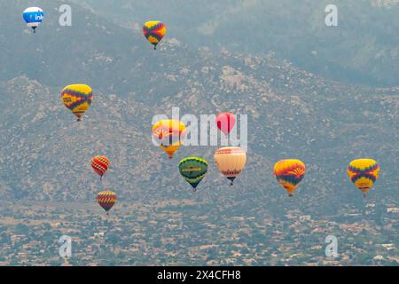 USA, New Mexico, Albuquerque. Heißluftballons fliegen bei Sonnenaufgang über die Stadt. (Nur Für Redaktionelle Zwecke) Stockfoto
