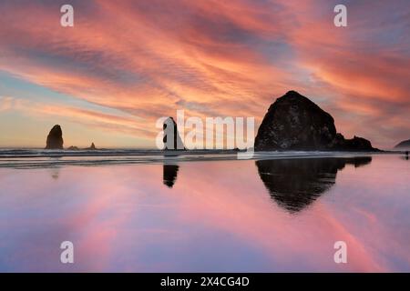 USA, Oregon. Cannon Beach und Haystack Rock bei Sonnenuntergang und Ebbe Stockfoto