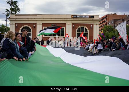 Barcelona, Spanien. Mai 2024. Die Demonstranten halten während der Demonstration eine riesige palästinensische Flagge. Tausende von Menschen marschierten in Barcelona und in den wichtigsten Städten Spaniens und forderten am Internationalen Arbeitstag bessere Löhne und Arbeitsbedingungen. Quelle: SOPA Images Limited/Alamy Live News Stockfoto