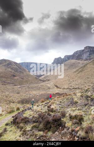 Spaziergänger auf dem Fußweg, der zum Quiraing führt, der Teil des Trotternish Berges ist, eine Touristenattraktion für Wanderer auf der Isle of Skye. Stockfoto