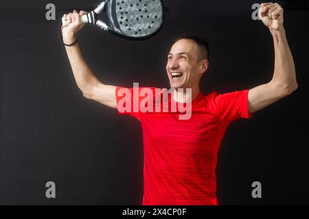 Lächelnder Mann mit Schläger und Paddelball in Sportkleidung gekleidet isolierter Hintergrund. Vorderansicht. Stockfoto