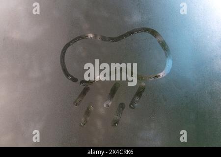 Bemalte Wolke mit Regen auf das beschlagene Glas, kopiere den Raum. Vorstellung von regnerigem Wetter, schlechter Stimmung. Anzeichen von schlechtem Wetter Stockfoto