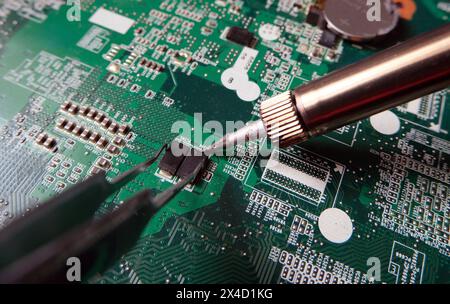 Montage oder Demontage von Komponenten auf Hightech-Elektronikplatinen. Arbeiten mit Halbleitern. Stockfoto