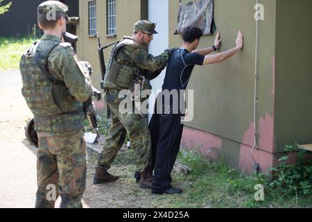 Darstellung: Soldaten auf Streife nehmen einen Verdaechtigen fest und ueberpruefen ihn, Leibesvisitation, Durchsuchung, allgemein, Feature, Randmotiv, Symbolfoto Kontrollposten, Checkpoint, Bundeswehr-Uebung AGILES ROSS im Rahmen der bundesweiten Uebung NATIONALWÄCHTER, die nordrhein-westfaelischen Heimatschutzkraefte des Heimatschutzregiments 2 aus Münster uebenin der Wahner Heide bei Troisdorf Altenrath, 02.05.2024, *** Bildsoldaten auf Patrouille verhaften einen Verdächtigen und überprüfen, Körpersuche, allgemein, Merkmal, Grenzmotiv, symbolischer Fotocheckpunkt, Checkpoint, Bundeswehr Exercise AG Stockfoto