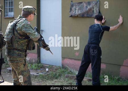 Darstellung: Soldaten auf Streife nehmen einen Verdaechtigen fest und ueberpruefen ihn, Leibesvisitation, Durchsuchung, allgemein, Feature, Randmotiv, Symbolfoto Kontrollposten, Checkpoint, Bundeswehr-Uebung AGILES ROSS im Rahmen der bundesweiten Uebung NATIONALWÄCHTER, die nordrhein-westfaelischen Heimatschutzkraefte des Heimatschutzregiments 2 aus Münster uebenin der Wahner Heide bei Troisdorf Altenrath, 02.05.2024, *** Bildsoldaten auf Patrouille verhaften einen Verdächtigen und überprüfen, Körpersuche, allgemein, Merkmal, Grenzmotiv, symbolischer Fotocheckpunkt, Checkpoint, Bundeswehr Exercise AG Stockfoto