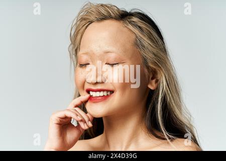 Eine attraktive asiatische Frau in bunter Kleidung, die strahlend lächelt. Stockfoto