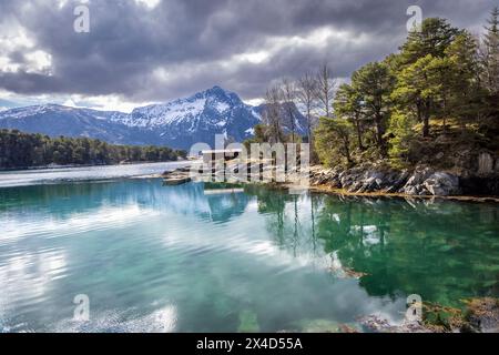 Idyllisch gelegene Hütte am Fjord zwischen den beiden Inseln Hestoya und Gronnoya in Nordland County, Norwegen Stockfoto