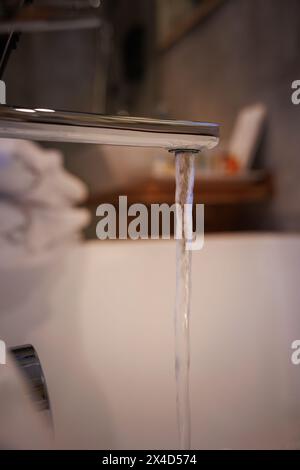 Badewannen-Wasserhahn offen mit Wasser in elegantem und schönem Bad zum Baden, Wasserabfall Stockfoto