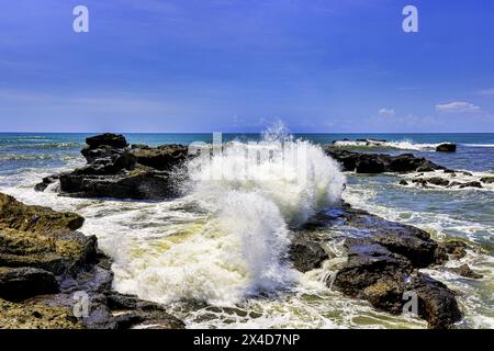 Wellen stürzen über die vulkanischen Felsinseln entlang der Südküste von Bali, Indonesien Stockfoto