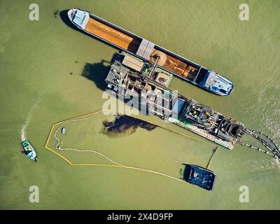 Das Binnenschiff Courage (110 Meter lang und 50 Meter breit) brach am Mittwochmorgen beim Verladen von Sand auf einem Ausgrabungsgelände am Waal bei Deest in den Niederlanden. Austretendes Öl aus dem Behälter ist über dem Wasser sichtbar. Die niederländische Generaldirektion für öffentliche Arbeiten und Wasserwirtschaft (Rijkswaterstaat) hat Ölbooms eingeführt, um Verschmutzungen zu verhindern. Die Unfallursache ist noch unklar. (Foto: Norbert Voskens / SOPA Images/SIPA USA) Stockfoto