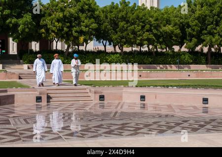 Drei Männer laufen in einem Innenhof in der Sultan Qaboos Grand Moschee, Maskat, Oman. (Nur Für Redaktionelle Zwecke) Stockfoto