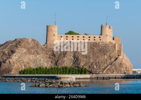 Ein Fort auf einer Klippe mit Blick auf den Sultan Qaboos Al-Alam Palast. Maskat, Oman. Stockfoto