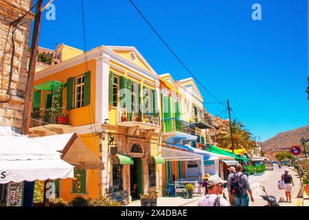 SYMI, Griechenland - 03. Juni 2021. Touristen auf der Hafenpromenade von Symi Stadt. Das schönste und romantischste Viertel der gesamten Ägäis. Stockfoto