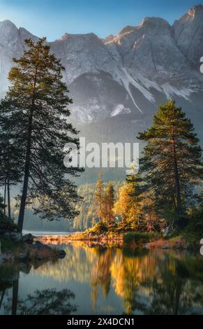 Idyllische Landschaft am Deutschen Eibsee in den Alpen, mit Bergen und Bäumen im klaren Wasser und schönem Licht Stockfoto