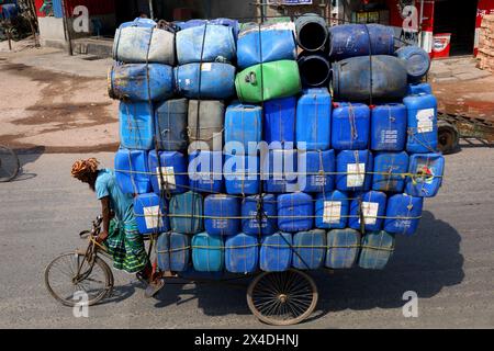 Dhaka, Dhaka, Bangladesch. Mai 2024. Ein Arbeiter trägt Plastikfässer in einem dreirädrigen Van in Sadarghat in Dhaka. Im Allgemeinen werden diese Fässer für den Öltransport verwendet. (Kreditbild: © Syed Mahabubul Kader/ZUMA Press Wire) NUR REDAKTIONELLE VERWENDUNG! Nicht für kommerzielle ZWECKE! Stockfoto