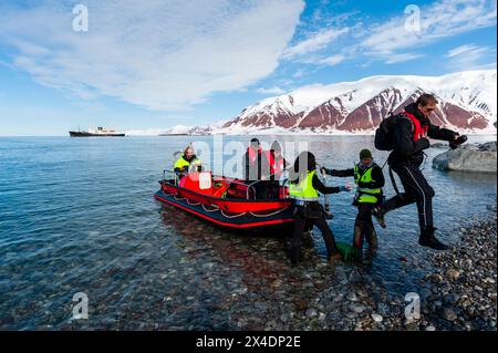 Touristen steigen von einem Schlauchboot an die Küste des Bockfjordens aus. Spitzbergen Island, Svalbard, Norwegen. (Nur Für Redaktionelle Zwecke) Stockfoto