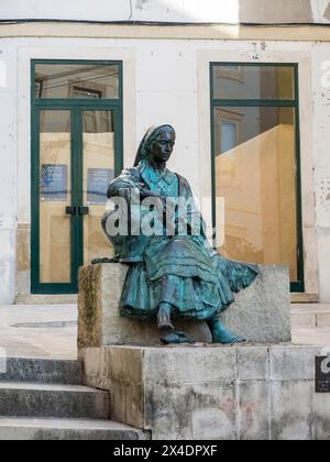 Bronzestatue einer Frau in traditioneller portugiesischer Tracht in Rua do Quebra-Costas im historischen Zentrum von Coimbra. Stockfoto