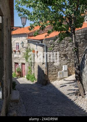 Altes portugiesisches Dorf, das auf der Seite eines Berges zwischen großen Felsbrocken mit Kopfsteinpflasterstraßen und Häusern erbaut wurde. Stockfoto