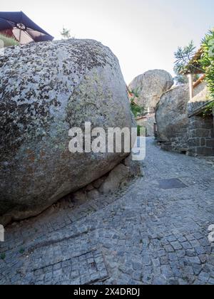 Altes portugiesisches Dorf, das auf der Seite eines Berges zwischen großen Felsbrocken mit Kopfsteinpflasterstraßen und Häusern erbaut wurde. Stockfoto