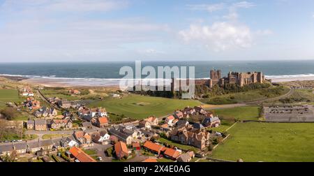 BAMBURGH CASTLE, NORTHUMBERLAND, GROSSBRITANNIEN - 23. APRIL 2024. Panoramablick auf die Burg und das Dorf Bamburgh, das ein beliebter Tourist destin ist Stockfoto
