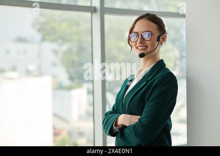Porträt einer lächelnden, selbstbewussten Geschäftsfrau, die beim Anruf mit einem Kollegen ein Headset mit Freisprechfunktion trägt Stockfoto