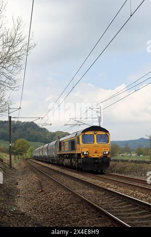 Die Diesellokomotive 66703 der GBRF nähert sich einem Fußübergang über die Bahnstrecke am Ende der Parkers Lane in Low Utley im Aire Valley in West Yorkshire Stockfoto