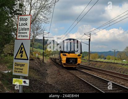 Ein nördlicher Elektrozug überquert die Sicherheitsschilder am Ende der Parkers Lane in Low Utley im Aire Valley. Stockfoto