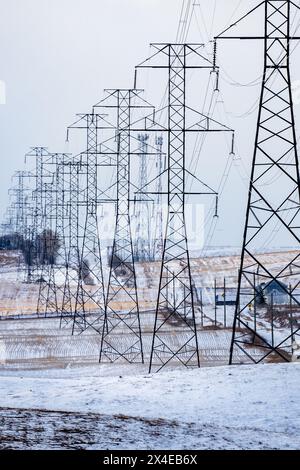 Elektrische Pylonen im Hochformat mit Stromleitungen mit Blick auf die Felder im ländlichen Alberta Kanada. Stockfoto