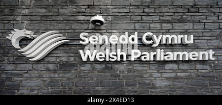 Cardiff Bay Schild auf grauer Schieferwand für das walisische Parlament - Senedd Cymru vor dem walisischen Parlamentsgebäude im Mai 2024 Stockfoto