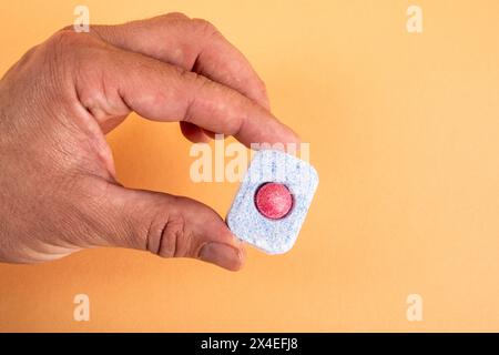 Geschirrspülkapsel in der Hand auf hellem Hintergrund. Stockfoto