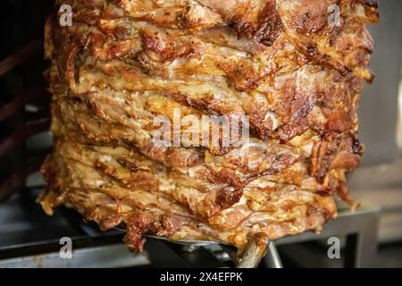 Gyros: Saftige, gewürzte Fleischscheiben, perfekt gegrillt, in eine warme Pita gewickelt, mit frischen Tomaten, Zwiebeln und cremiger Tzatziki-Sauce garniert Stockfoto