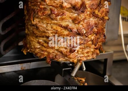 Gyros: Saftige, gewürzte Fleischscheiben, perfekt gegrillt, in eine warme Pita gewickelt, mit frischen Tomaten, Zwiebeln und cremiger Tzatziki-Sauce garniert Stockfoto