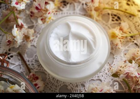 Hausgemachte Rosskastaniencreme in einem Glas auf einem Tisch mit Freh Aesculus hippocastanum Blüten, die im Frühjahr gesammelt wurden Stockfoto